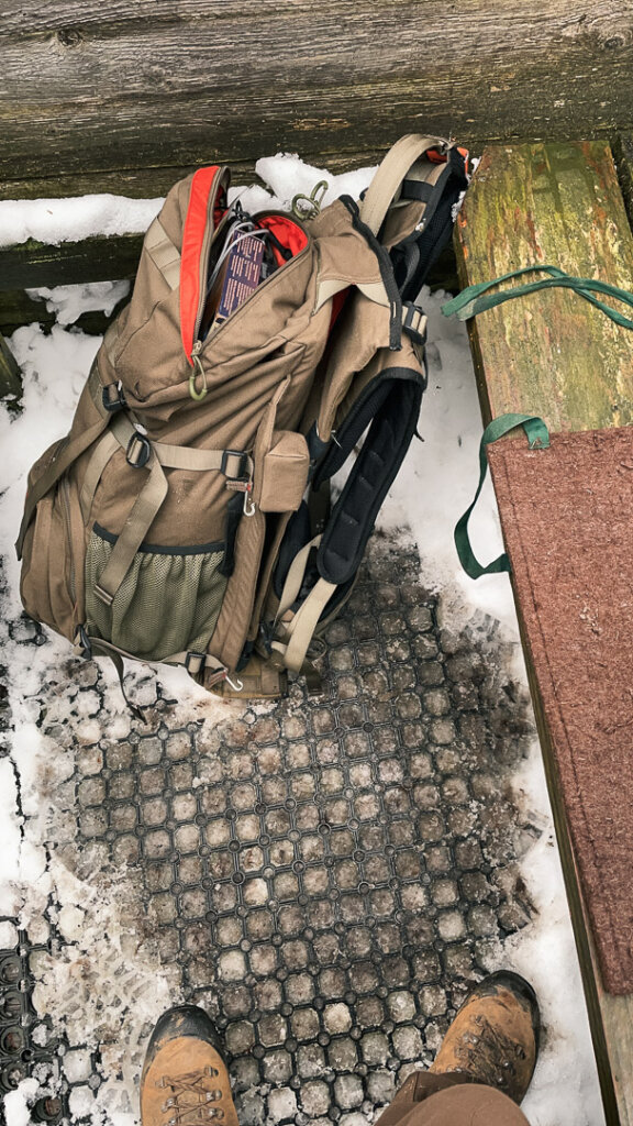 Vorn Deer als Rucksack für die Drückjagd neben einem Filzsitzkissen auf dem Bock
